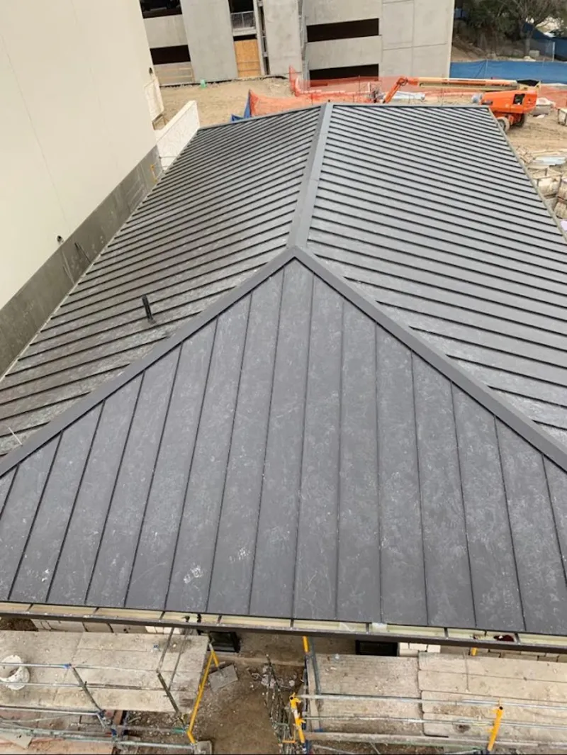 Commercial metal roof construction with crane equipment in Parker